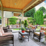 Cozy covered sitting area with wicker chairs and swing bench. Northwest, USA
