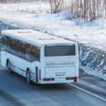 bus is driving on a country road in winter