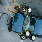 Firefighters using a glass cutter to cut car windscreen after accident.